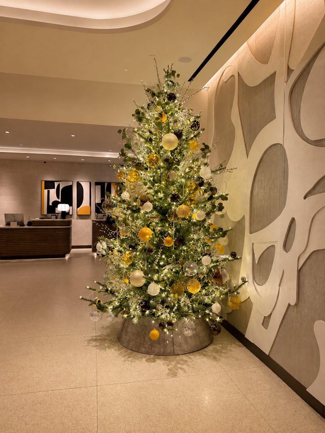 Hotel lobby Christmas tree with gold and white ornaments near the entrance, styled by Light the Lights