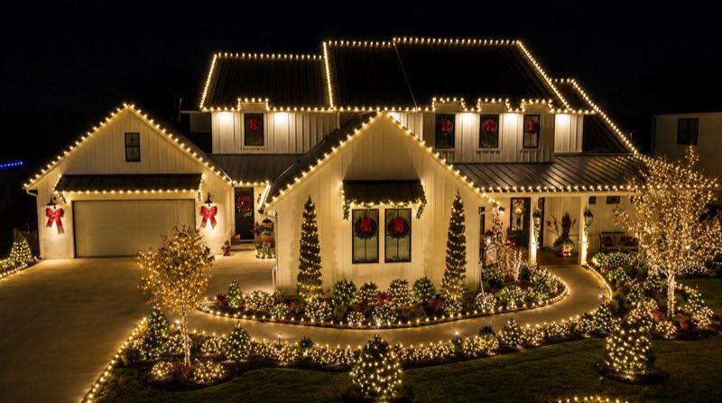 Modern farmhouse with full roofline holiday lighting and lit trees, Wesley Chapel FL